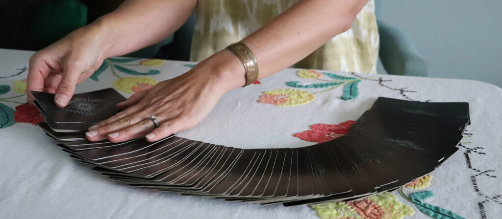 Image of hands with tarot cards, links to Teach me Tarot